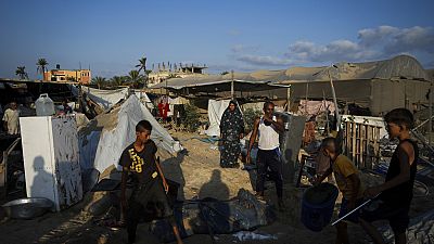 Palestinians look at the destruction after an Israeli airstrike on a crowded tent camp housing Palestinians displaced by the war in Muwasi, Gaza Strip, Tuesday, Sept. 10, 2024