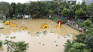 People watch a submerged dragon structure in a playground, following Typhoon Yagi in Hanoi, Vietnam on Tuesday, Sept. 10, 2024.