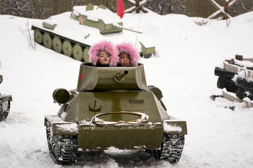 Children ride a model of World War II-era Soviet T-34 tank during a military historical festival at the family historical tank park outside St Petersburg, 4 February 2023