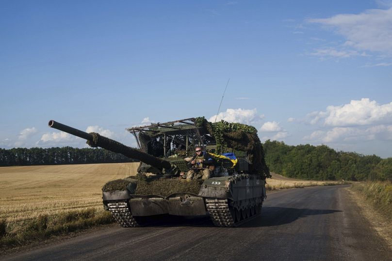 Ukrainian serviceman ride atop a trophy tank after returning from Russia near the Russian-Ukrainian border in Sumy region, Ukraine, Thursday, Aug. 15, 2024.