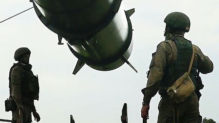 Russian soldiers load a short-range ballistic missile launchers at a firing position as part of Russian military drill intended to train the troops in using tactical weapons