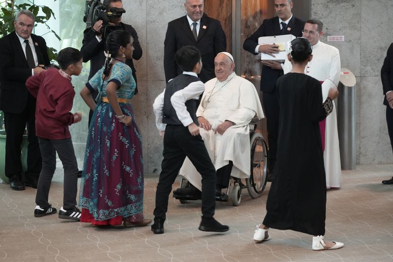 Papa Francisco é recebido por crianças dançando ao chegar ao Aeroporto Internacional Changi de Singapura.