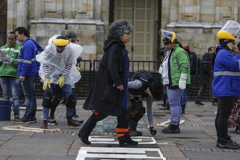  Doris Salcedo caminha entre ativistas que trabalharam na sua instalação artística na Plaza Bolivar, no centro de Bogotá, Colômbia, segunda-feira, 10 de junho 2010