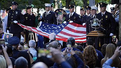 A New York Police Department honor guard holds an American flag during a 9/11 commemoration ceremony at Ground Zero, in New York, Wednesday, Sept. 11, 2024.