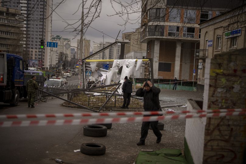 Police officers inspect an area after an apparent Russian strike in Kyiv Ukraine, Thursday, Feb. 24, 2022. 