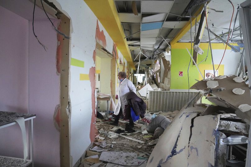 A medical worker walks through the hall of a maternity hospital damaged in a shelling attack in Mariupol, Ukraine, Wednesday, March 9, 2022.