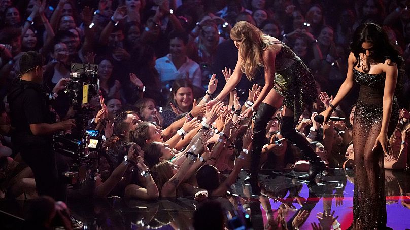 Taylor Swift com fãs ao aceitar o prémio por "Fortnight" das mãos de Megan Thee Stallion nos MTV Video Music Awards 