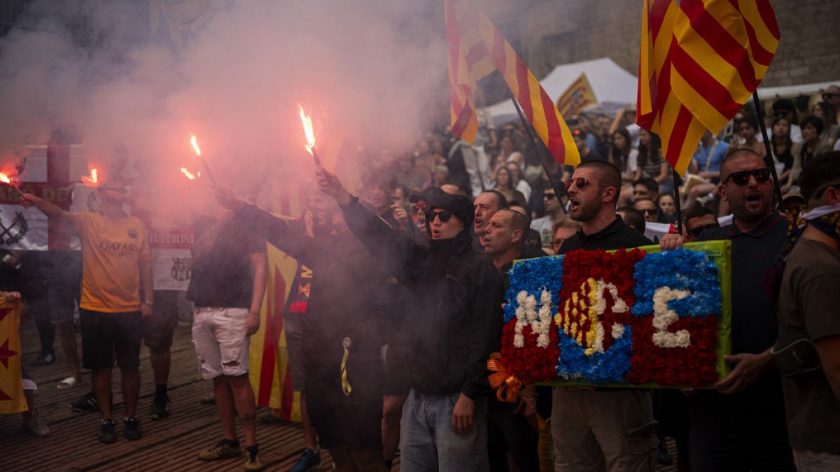 Protesters hold independence flags and flares as they shout slogans calling for Catalonia's independence from Spain, during the Catalan National Day, called "Diada".