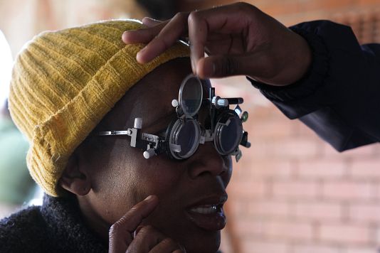 A patient eyes are tested for lenses to be made for a new pair of glasses outside the Phelophepa eye clinic carriage, in Tembisa, South Africa, on Aug. 22, 2024.