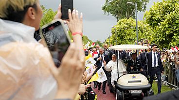 Pope Francis travels in a buggy as he greets the volunteers on his arrival in Singapore, Wednesday, Sept. 11, 2024.