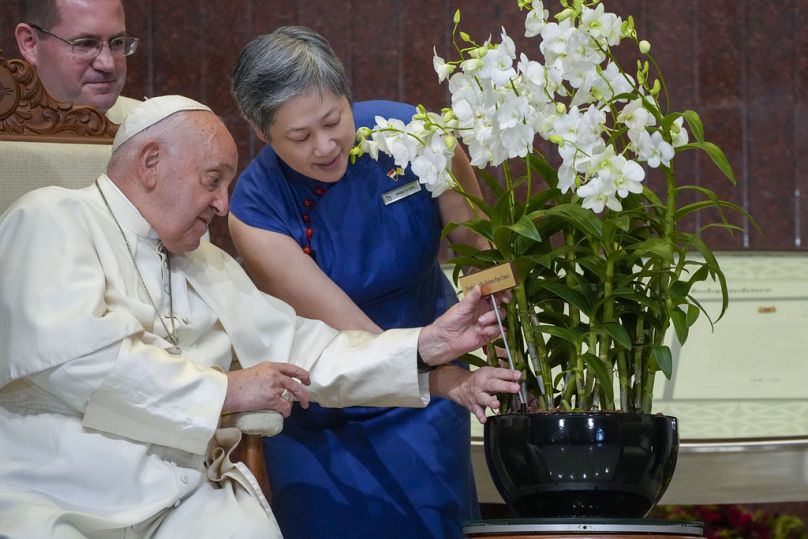 Pope Francis with a 'Dendrobium His Holiness Pope Francis', a specially bred orchid variety named after him at the Parliament House in Singapore, Thursday, Sept. 12, 2024.