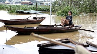 Une femme pagaie sur un bateau dans une rue inondée, suite au typhon Yagi à Hanoi, au Vietnam,