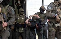 FILE - Kosovo police members escort one of the arrested Serb gunmen out of the court after the Kosovo shootout in capital Pristina, on Tuesday, Sept. 26, 2023.