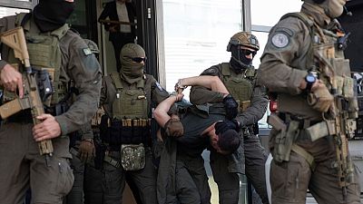 FILE - Kosovo police members escort one of the arrested Serb gunmen out of the court after the Kosovo shootout in capital Pristina, on Tuesday, Sept. 26, 2023.