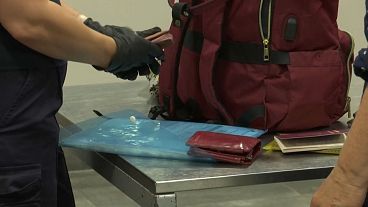 A pedestrian's luggage is inspected by an Estonian border agent at the Narva crossing, September 12, 2024