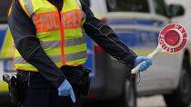 A German federal police officer stops cars and trucks at a border crossing point between Germany and Czech Republic in Furth am Wald, Germany.