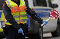 A German federal police officer stops cars and trucks at a border crossing point between Germany and Czech Republic in Furth am Wald, Germany.