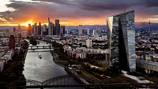 The sun sets over the buildings of the banking district, rear left, and the European Central Bank, front right, in Frankfurt, Germany, Wednesday, Sept. 11, 2024. 