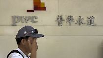 A man walks by the office of audit firm PwC, at the Fortune Financial Center in Beijing. 27 August 2024.