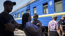 Une famille attend le train d'évacuation à Pokrovsk, dans la région de Donetsk, en Ukraine, le lundi 19 août 2024. 