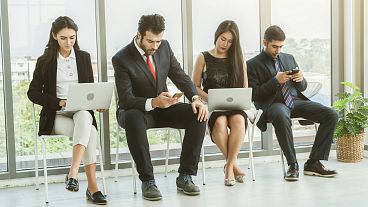 Four people sitting and waiting for interviews