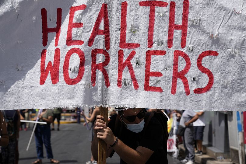 A supporter of health workers holds a banner during a rally in Athens, Greece.