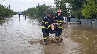 In this photo released by the Romanian Emergency Services Galati (ISU Galati), a rescuer carries a woman in Pechea, Romania, Saturday, Sept. 14, 2024