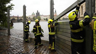 Bomberos ajustan partes de las barreras antiinundaciones en Praga, 13 de septiembre de 2024.