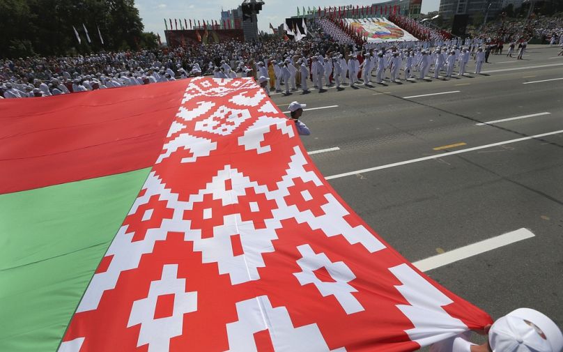 Des athlètes biélorusses portent le drapeau du pays lors des célébrations du Jour de l'Indépendance à Minsk, Bélarus, le 3 juillet 2013. 