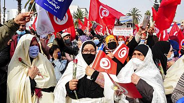 FILE - Sostenitori del partito islamista Ennada marciano con bandiere tunisine durante una manifestazione a Tunisi, Tunisia, sabato 27 febbraio 2021.