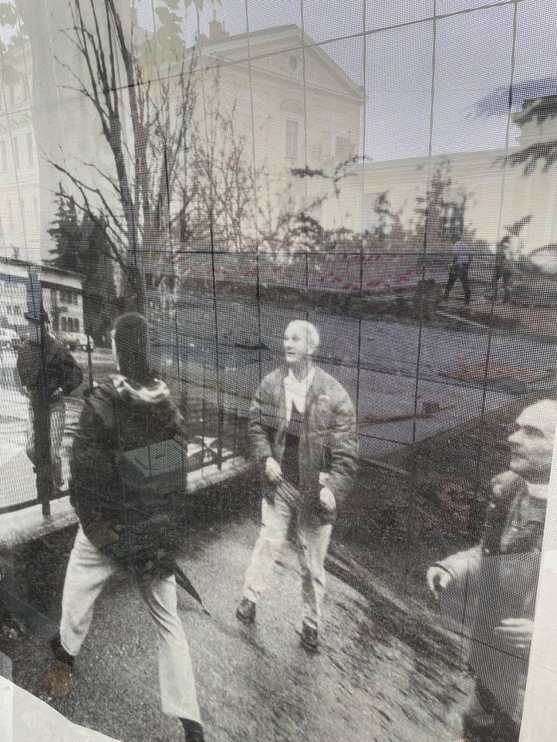 Work goes on at the central station, foregrounded by a photo of a cross-border game of volleyball in 1995