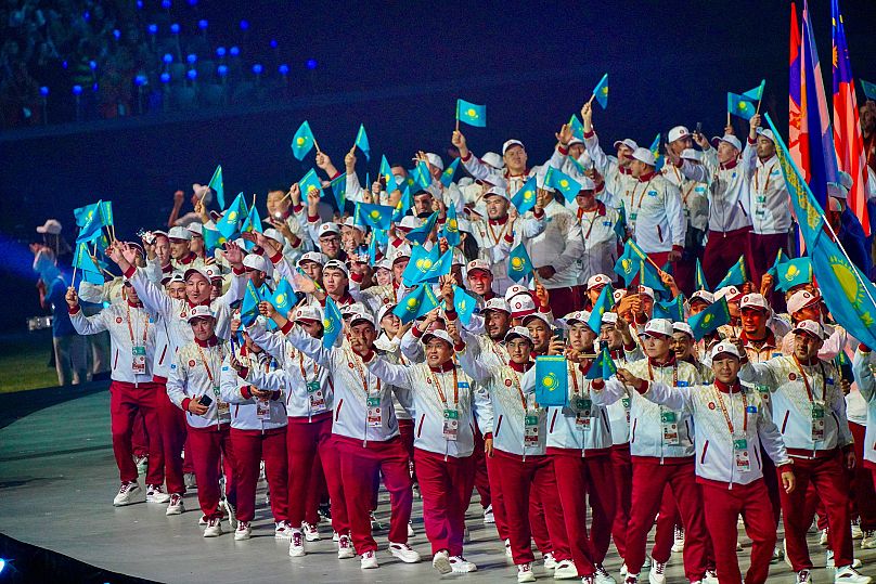  Athletes from Kazakhstan wave flags at the opening ceremony