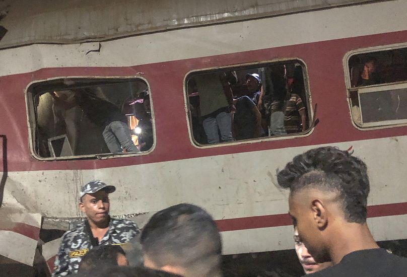 People surround two passenger trains which collided in Egypt's Nile Delta city of Zagazig, September 14, 2024