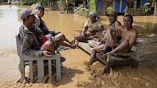 Myanmar'ın Naypyitaw kentinde sular altında kalan bir yolda bankta oturan yerel sakinler, 14 Eylül 2024, Cumartesi