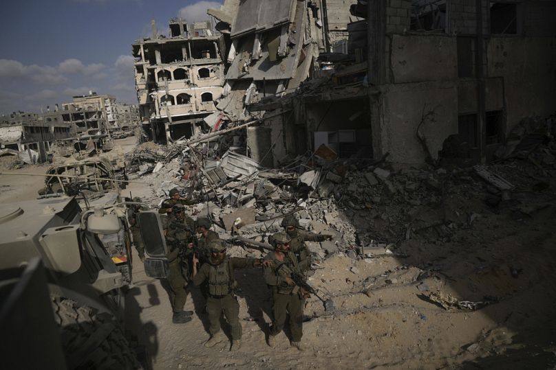 جنود إسرائيليون يتخذون مواقعهم بجوار المباني التي قاموا بتدميرها في قطاع غزة، الجمعة، 13 سبتمبر، 2024.