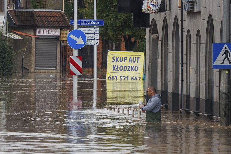 Un homme se tient dans l'eau dans la ville de Kłodzko, dans le sud-ouest de la Pologne, le dimanche 15 septembre 2024, après des jours de pluies diluviennes.