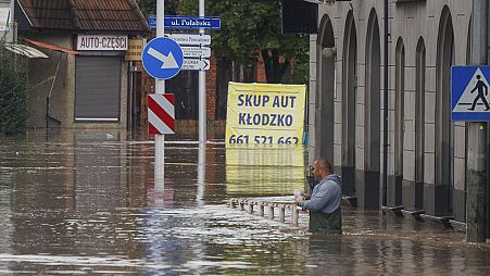 A man stands in waist-deep water that has flooded the streets and houses in the town of Kłodzko, in Poland's southwest, Sunday, Sept. 15, 2024, after days of heavy rain.