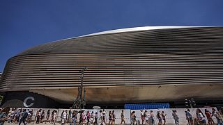 Aficionados hacen cola para el concierto de Taylor Swift a las puertas del estadio Santiago Bernabéu de Madrid en mayo de 2024