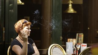 Archivo: Una mujer fuma a la salida de un bar en el centro de Ámsterdam, Países Bajos, el martes 1 de julio de 2008. 