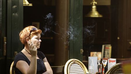 A woman smokes outside a bar in central Amsterdam, the Netherlands, Tuesday, July 1, 2008. 