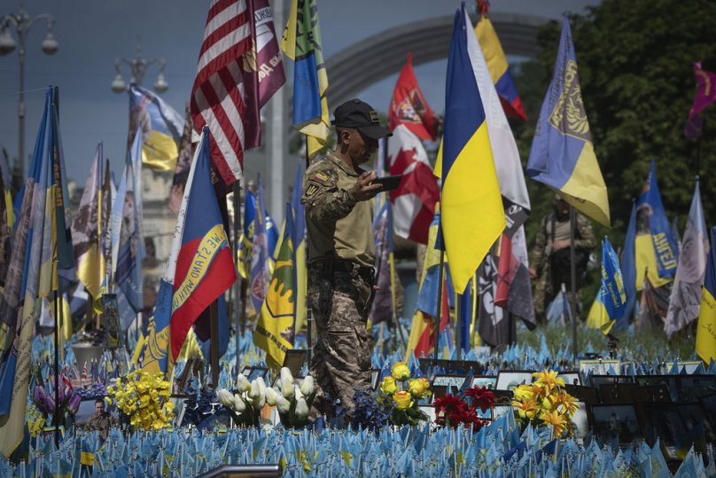 Un soldato colombiano volontario della Legione Internazionale ucraina in un memoriale improvvisato per i soldati ucraini caduti in Piazza Indipendenza a Kiev, luglio 2023