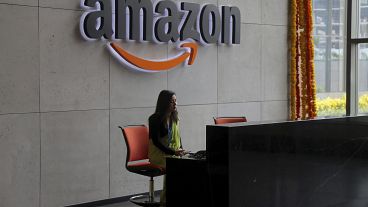 An Indian employee works at the reception desk of Amazon's newly inaugurated campus building in Hyderabad, India, Wednesday, Aug. 21, 2019.