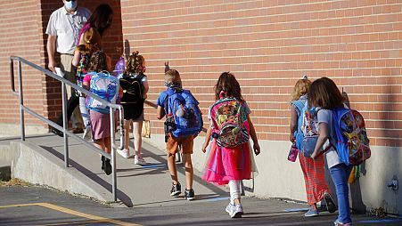  Nesta foto de arquivo de 17 de agosto de 2020, os alunos entram na Liberty Elementary School durante o primeiro dia de aula em Murray, Utah.