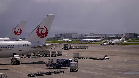 Japan Airlines uçakları Tokyo'daki Haneda uluslararası havalimanında bir terminalde park halindedir.