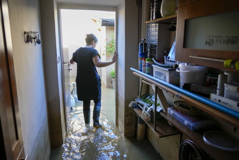 Uma mulher entra na casa da família inundada, em Bohumin, na Chéquia