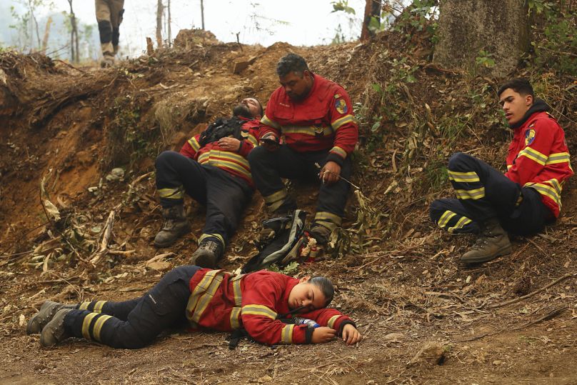 Los bomberos descansan durante una pausa en la lucha contra el fuego en las afueras de Sever do Vouga, localidad del norte de Portugal.