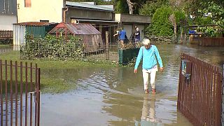 On the flooded road, a woman walks.