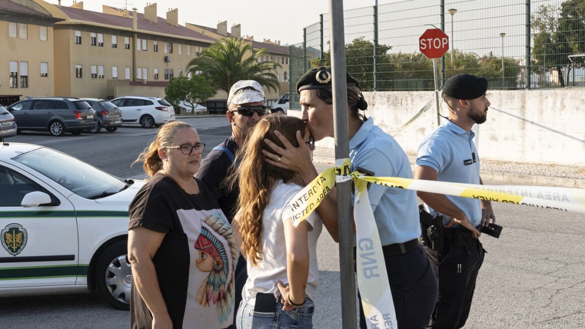 Una policía besa a una niña fuera de una escuela donde un niño de 12 años apuñaló e hirió a otros seis niños en Azambuja, cerca de Lisboa, el martes 17 de septiembre de 2024. 