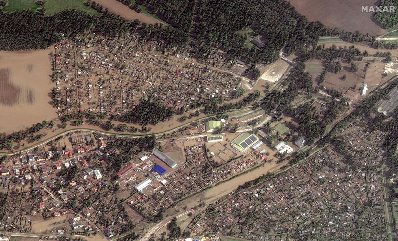 This satellite image released by Maxar Technologies shows flooded homes and businesses following heavy rains in Kravare, Czech Republic.