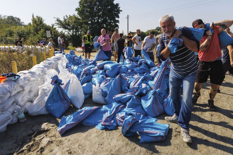 Des habitants de Wroclaw en Pologne utilisent des sacs de sable pour renforcer la digue du fleuve Oder prêt à déborder. 